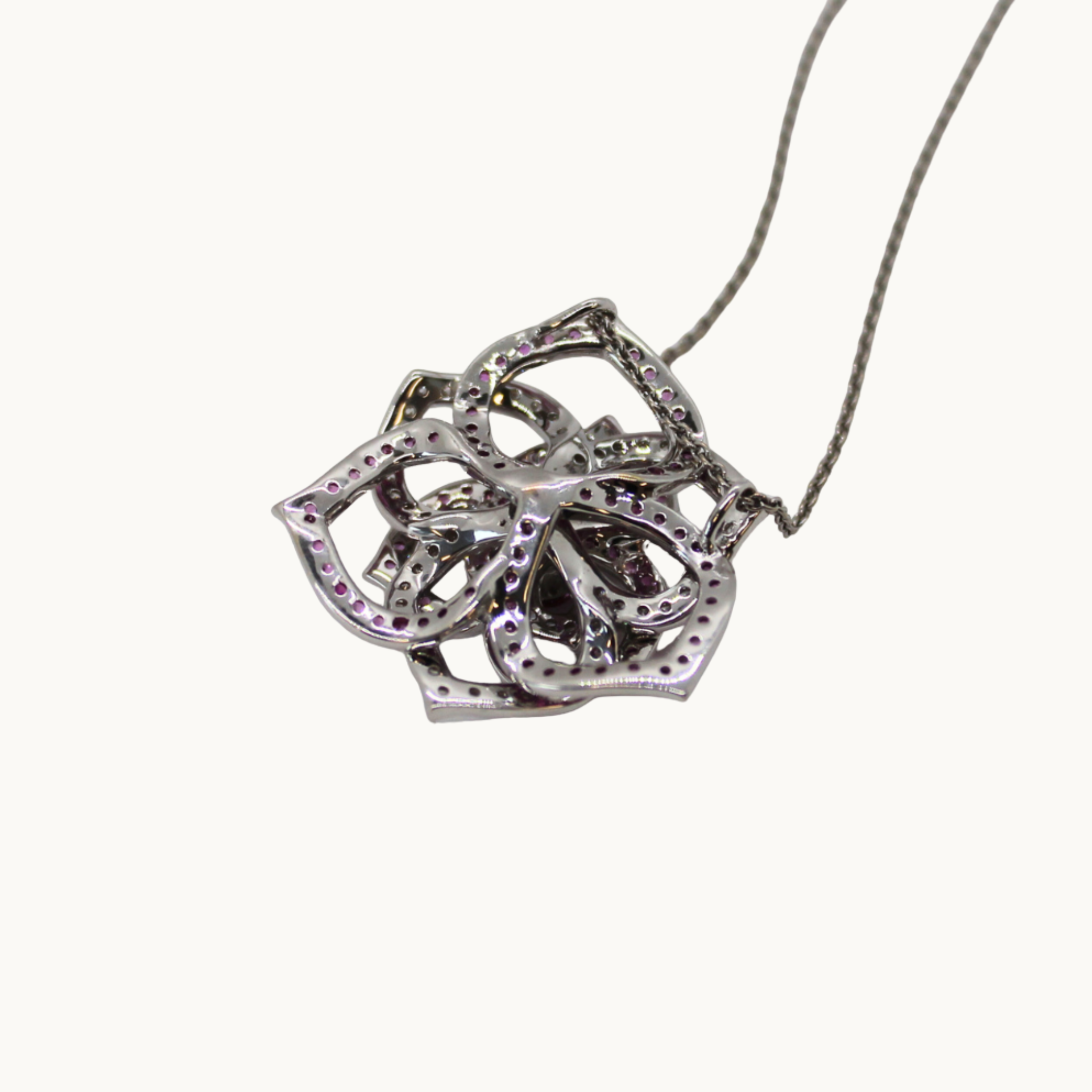 Rose-style pendant with 18K white gold, pink sapphires, and diamonds