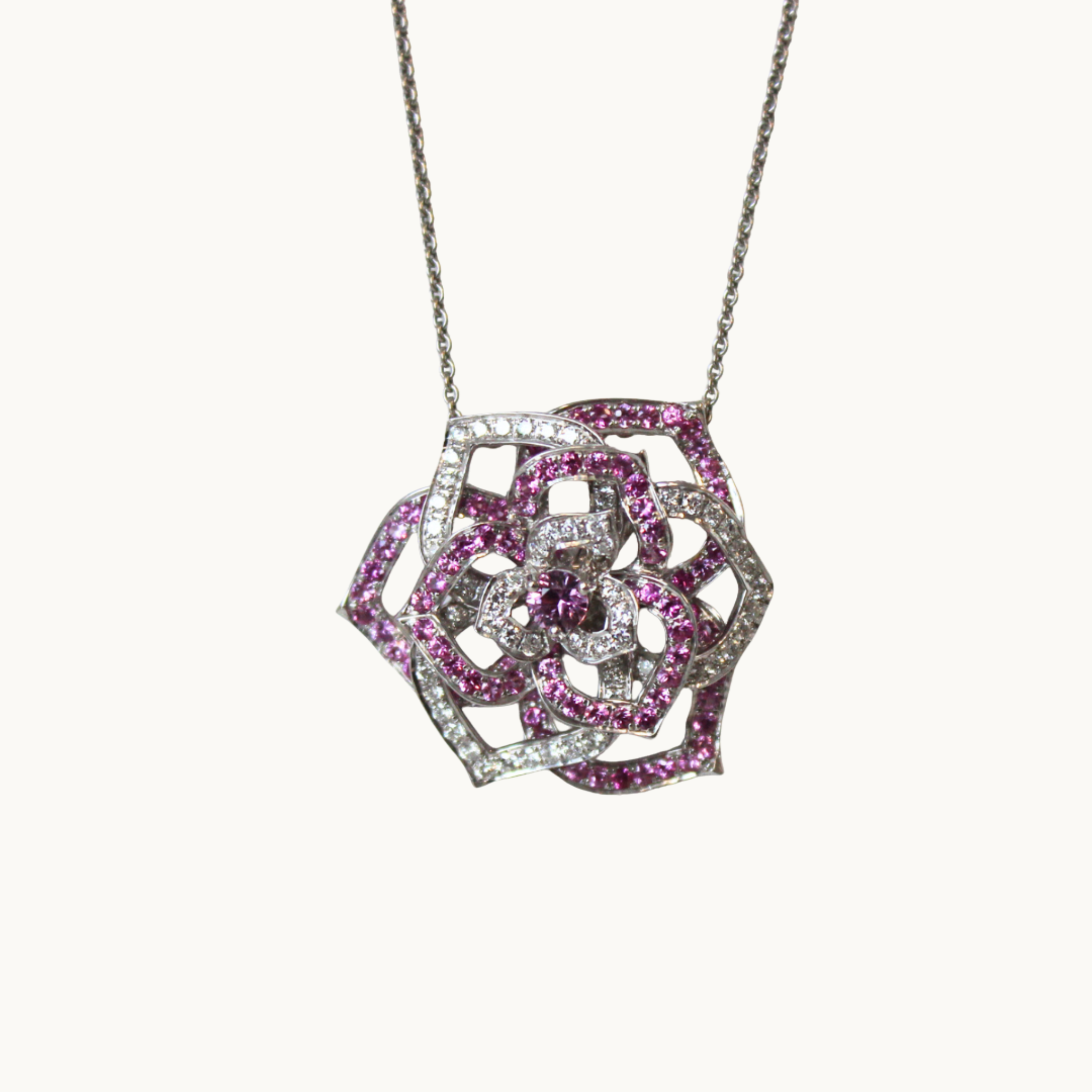 Rose-style pendant with 18K white gold, pink sapphires, and diamonds