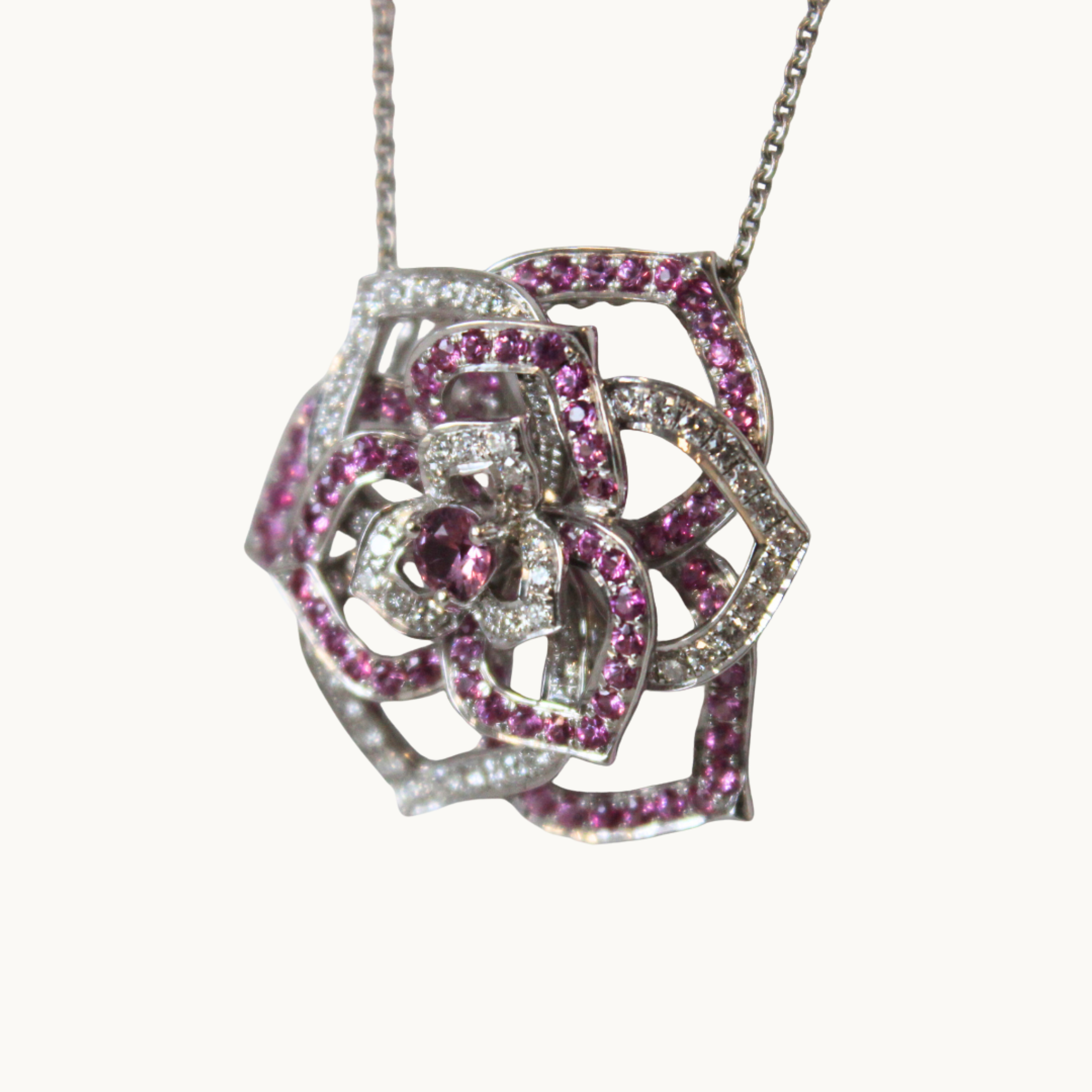 Rose-style pendant with 18K white gold, pink sapphires, and diamonds